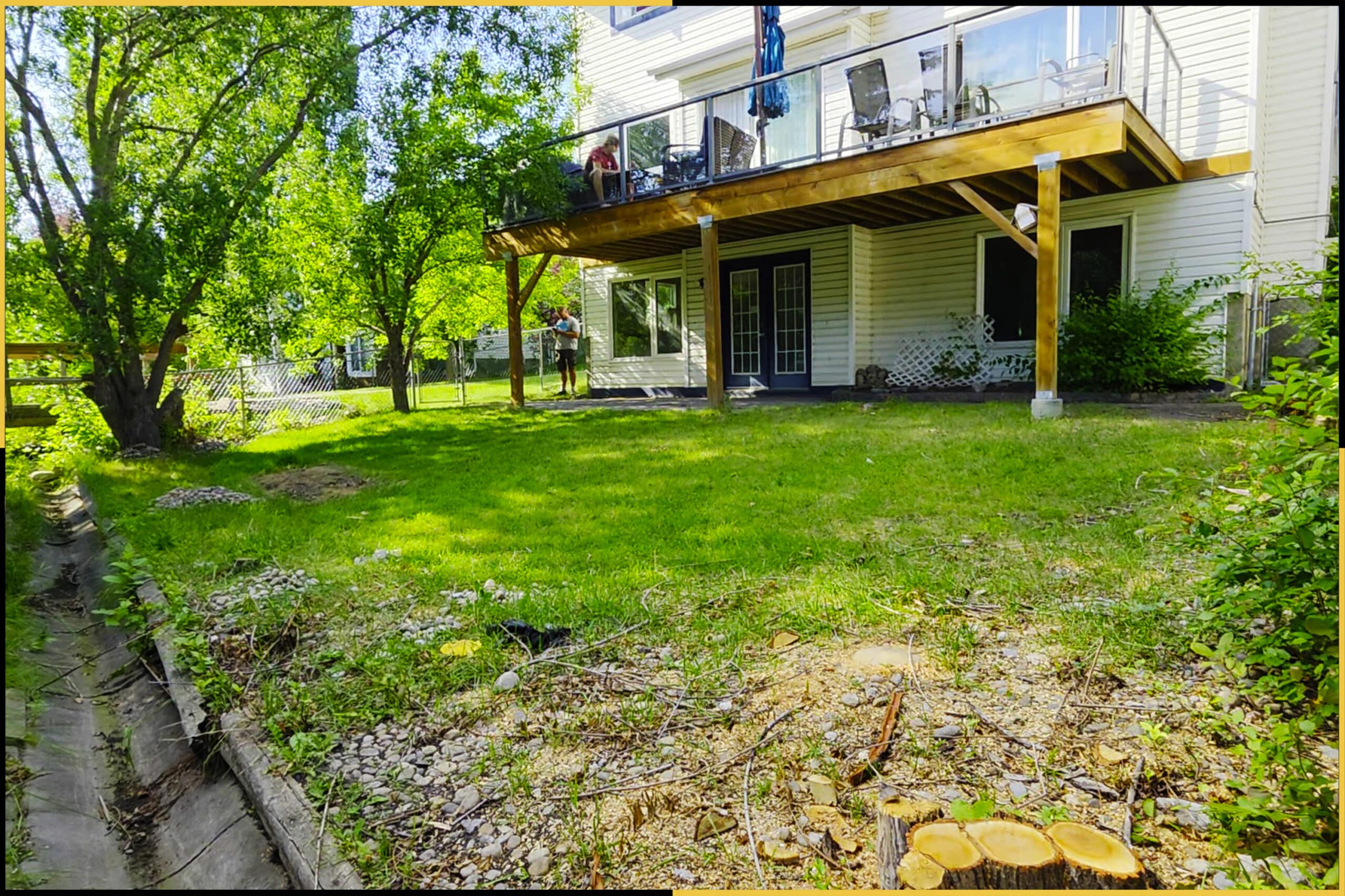 Before: sloped backyard with patchy grass below the deck