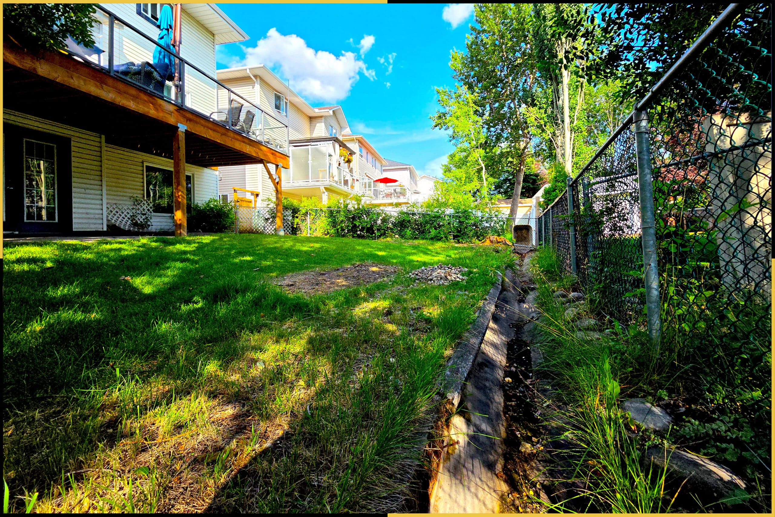 Before: uneven side yard with bare patches along the fence